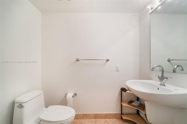 bathroom featuring tile flooring and toilet