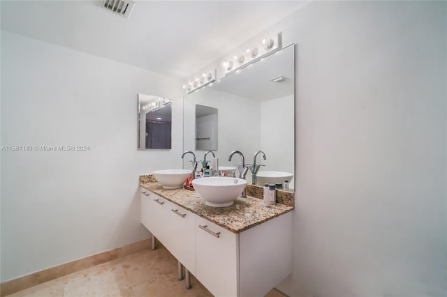 bathroom with tile floors, large vanity, and double sink