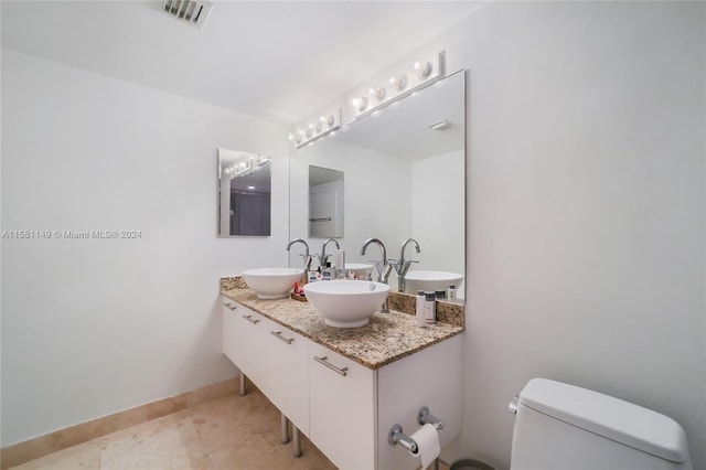 bathroom featuring vanity, toilet, and tile floors