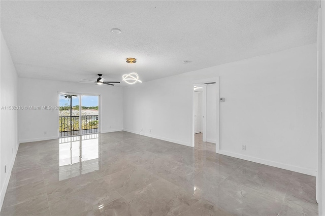 tiled spare room featuring ceiling fan and a textured ceiling