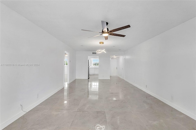 tiled empty room with ceiling fan