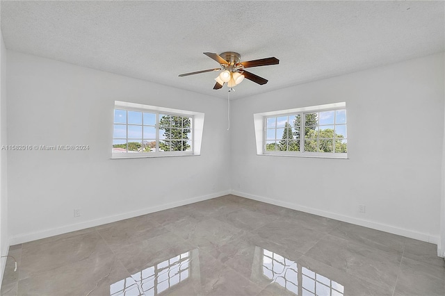 unfurnished room featuring a wealth of natural light, tile floors, and ceiling fan