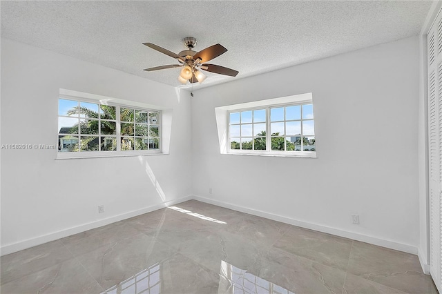 spare room featuring a textured ceiling, ceiling fan, and tile flooring