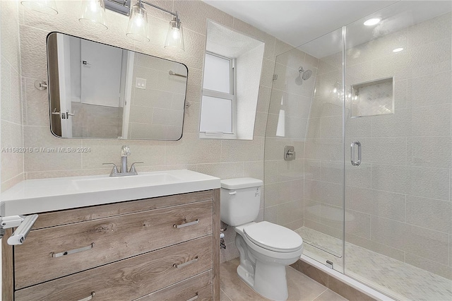 bathroom featuring tile floors, tile walls, vanity, and toilet