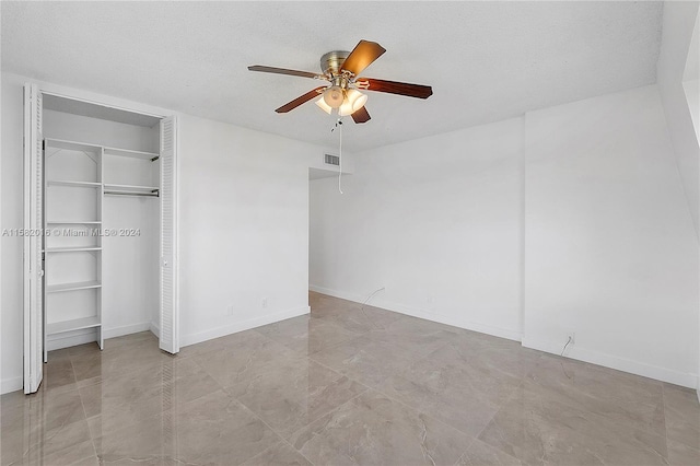 unfurnished bedroom featuring a closet, a textured ceiling, ceiling fan, and light tile floors