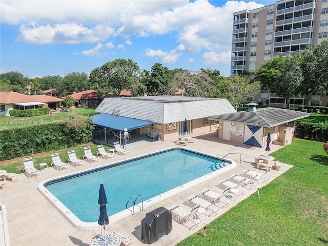 view of pool featuring a yard and a patio