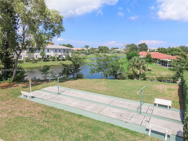 view of property's community with a water view and a yard