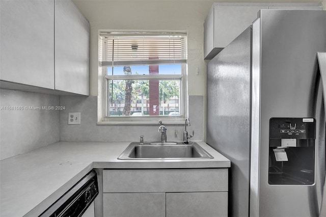 kitchen featuring stainless steel fridge with ice dispenser, backsplash, white dishwasher, white cabinetry, and sink