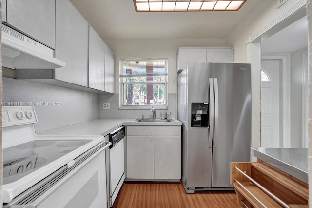 kitchen with ventilation hood, white appliances, light hardwood / wood-style floors, white cabinetry, and sink