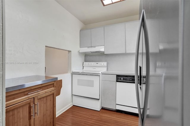 kitchen featuring white cabinets, hardwood / wood-style floors, and white appliances