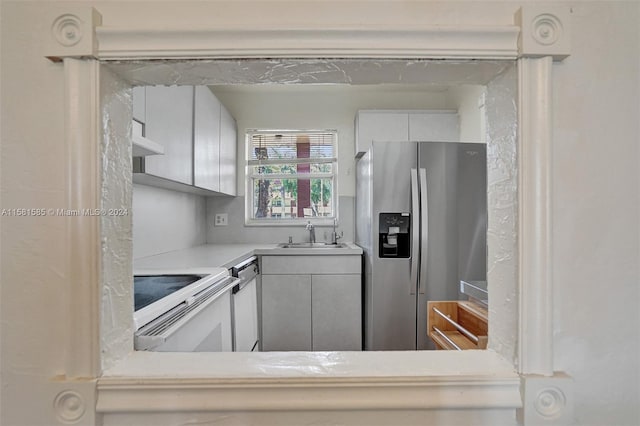 kitchen with white cabinets, sink, exhaust hood, and stainless steel appliances