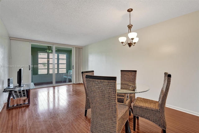 dining room with hardwood / wood-style floors, a notable chandelier, and a textured ceiling