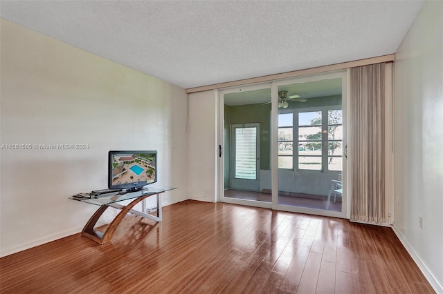 unfurnished room with wood-type flooring, ceiling fan, and a textured ceiling