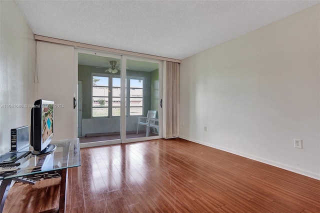 living room featuring a textured ceiling, hardwood / wood-style floors, and ceiling fan