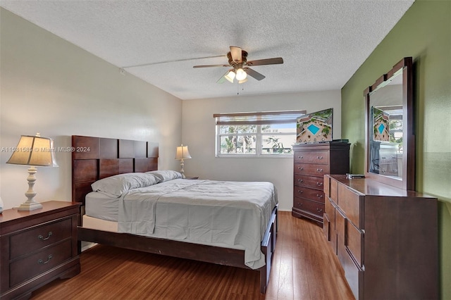 bedroom with hardwood / wood-style flooring, ceiling fan, and a textured ceiling