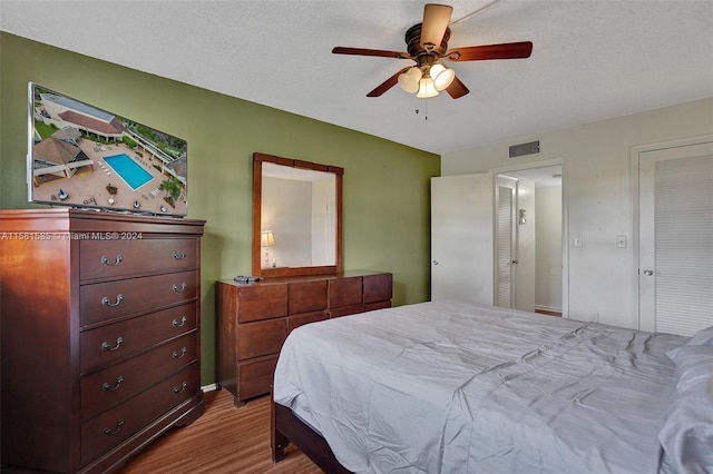 bedroom featuring a textured ceiling, ceiling fan, and hardwood / wood-style floors