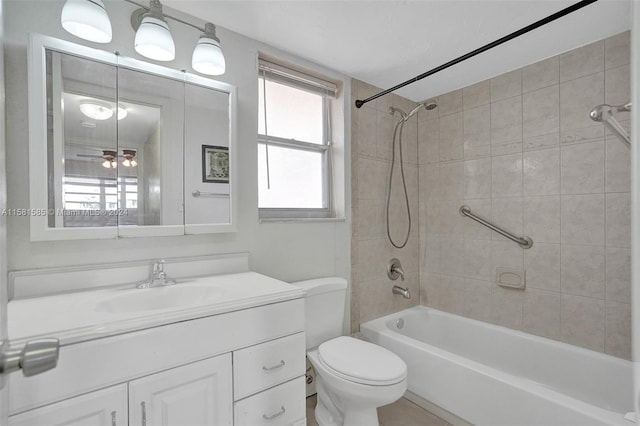 full bathroom with a healthy amount of sunlight, oversized vanity, toilet, and tiled shower / bath