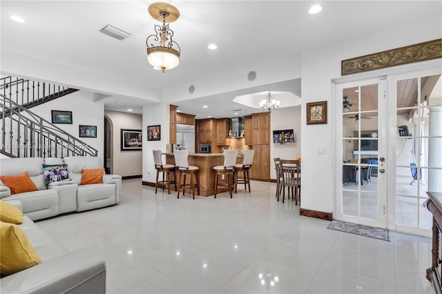 living room featuring light tile patterned floors, an inviting chandelier, and french doors