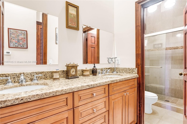 bathroom with a shower with shower door, toilet, dual vanity, and tile patterned flooring