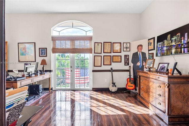 home office with a towering ceiling, french doors, and dark hardwood / wood-style floors