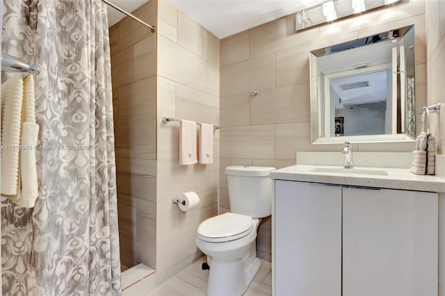 bathroom featuring tile walls, oversized vanity, toilet, and tile flooring