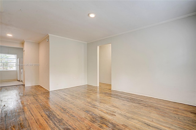 empty room with crown molding and light wood-type flooring