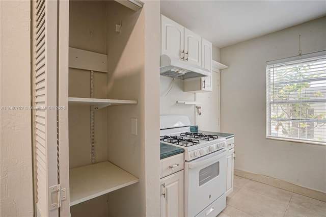 kitchen with white cabinetry, light tile patterned floors, and gas range gas stove