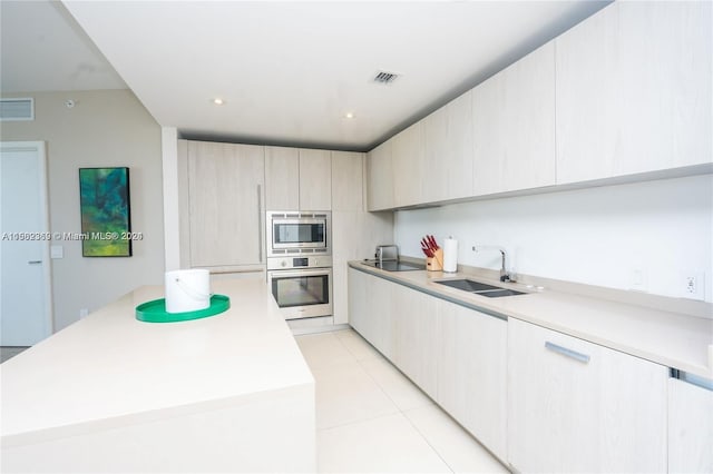 kitchen featuring sink, stainless steel appliances, and light tile flooring