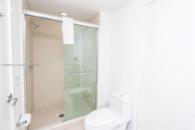 bathroom with toilet and a shower with shower door