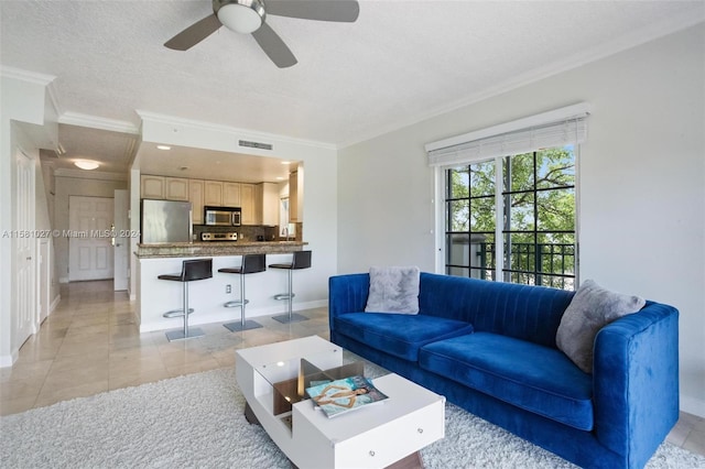 living room with ornamental molding, ceiling fan, and light tile floors