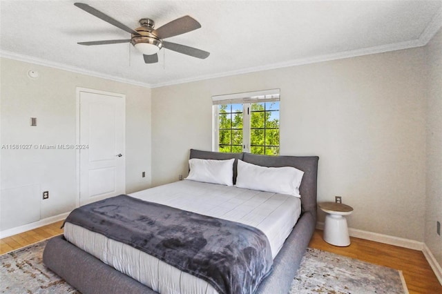 bedroom featuring ornamental molding, french doors, ceiling fan, and hardwood / wood-style flooring