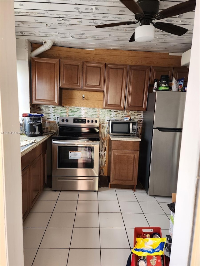 kitchen with ceiling fan, tasteful backsplash, light tile floors, and stainless steel appliances