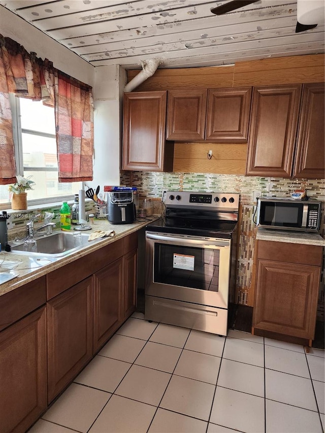 kitchen with sink, backsplash, stainless steel appliances, and light tile floors