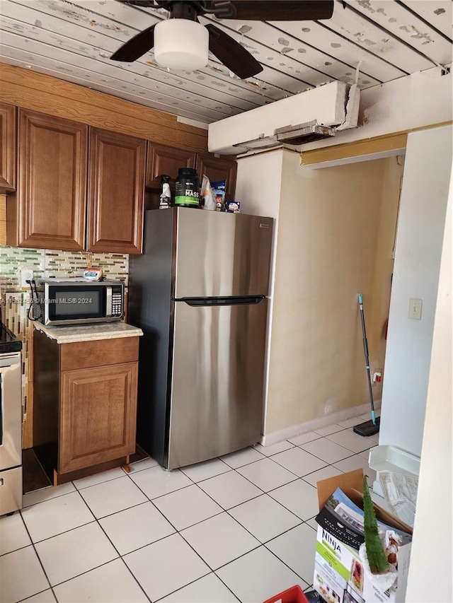 kitchen featuring appliances with stainless steel finishes, ceiling fan, tasteful backsplash, wooden ceiling, and light tile floors