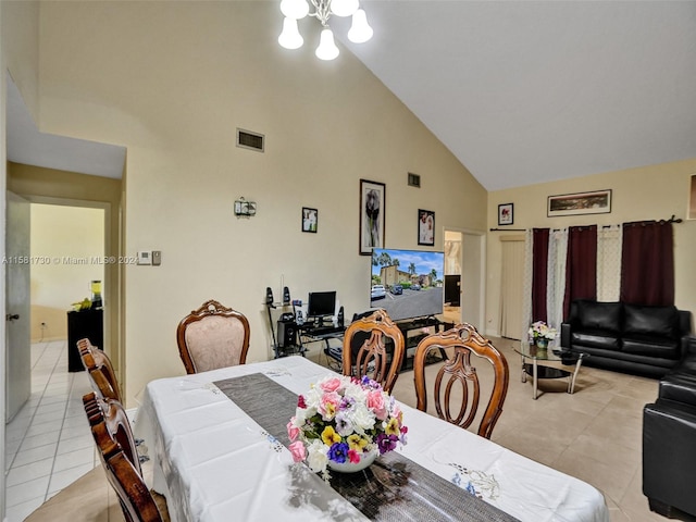 tiled dining area with high vaulted ceiling and an inviting chandelier