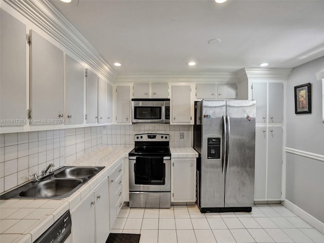 kitchen with backsplash, appliances with stainless steel finishes, sink, and light tile floors