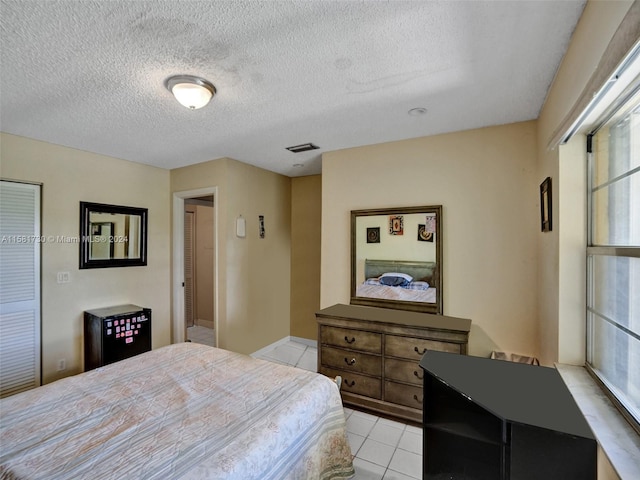 bedroom featuring a textured ceiling and light tile floors