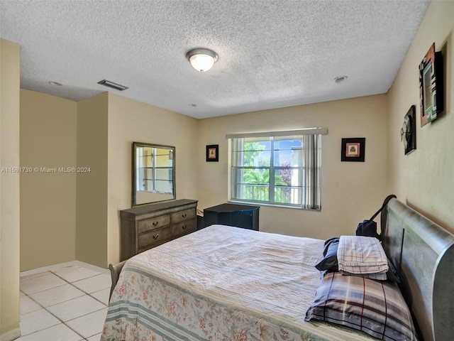 bedroom featuring tile floors and a textured ceiling