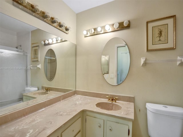 bathroom featuring vanity with extensive cabinet space and toilet