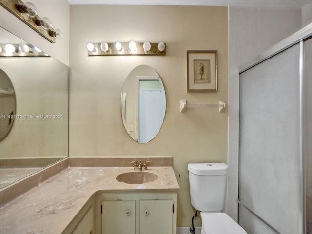 bathroom featuring vanity with extensive cabinet space and toilet