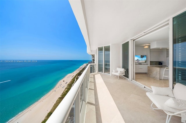 balcony featuring a view of the beach and a water view