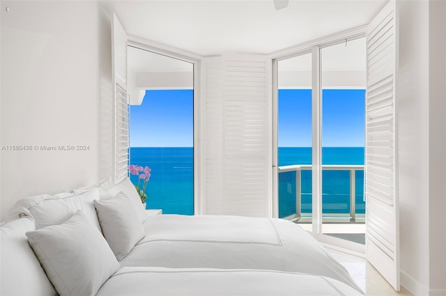 bedroom featuring floor to ceiling windows, multiple windows, a water view, and access to outside