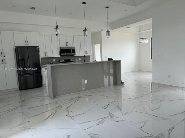 kitchen with a center island, light tile flooring, white cabinetry, decorative light fixtures, and stainless steel appliances