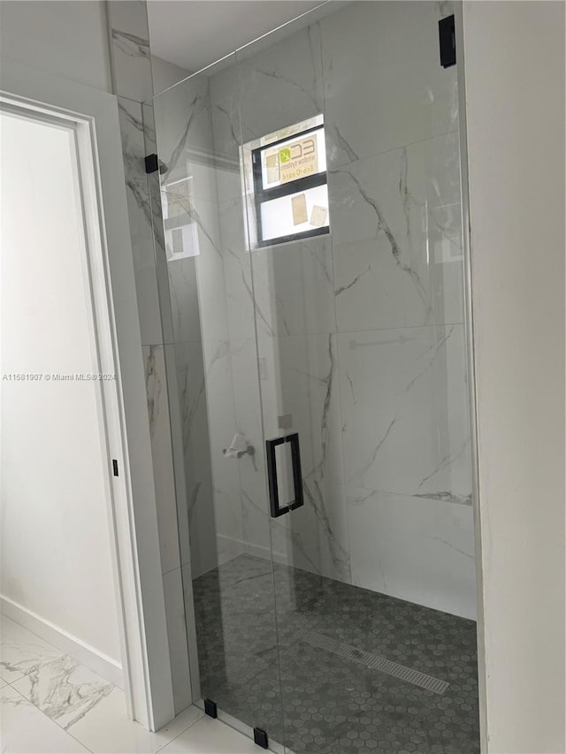 bathroom featuring a shower with shower door and tile floors