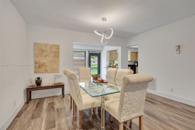 dining space with a notable chandelier and hardwood / wood-style floors