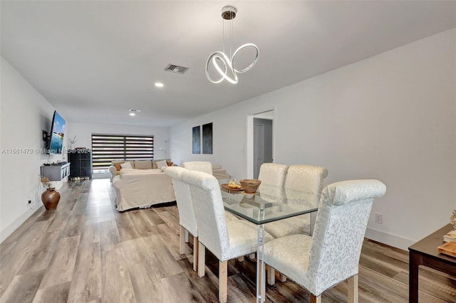 dining space with a notable chandelier and hardwood / wood-style flooring