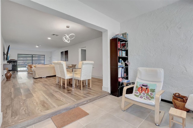 tiled dining space with a chandelier