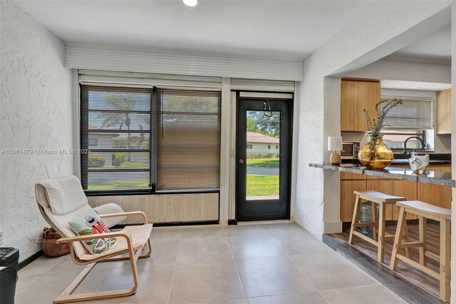 foyer entrance with sink and light tile floors