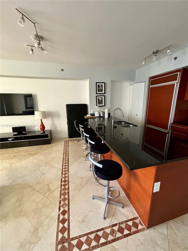 interior space featuring sink, light tile floors, and rail lighting