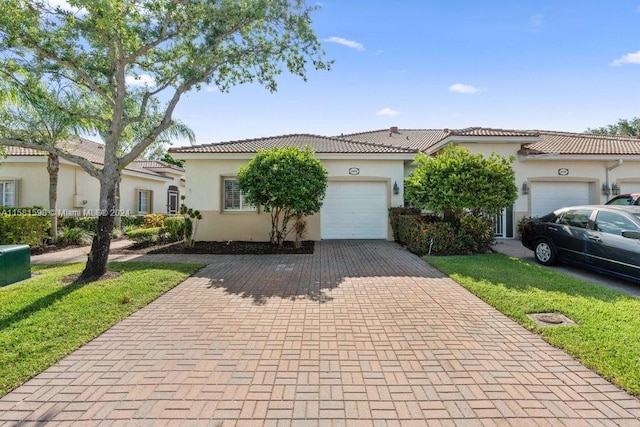 mediterranean / spanish-style house featuring a garage and a front yard